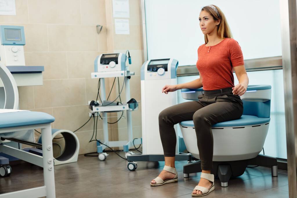 Young woman having non-invasive treatment for urinary incontinence at the clinic.